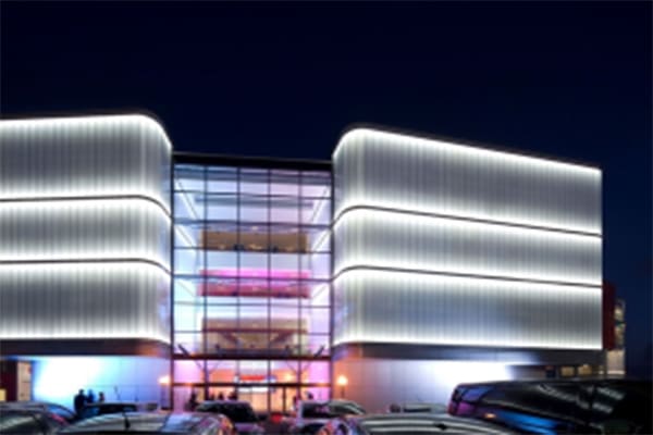 A modern building facade evenly illuminated by linear wall washer lights